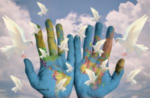 A world community painted on hands with doves
